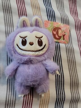 Babalu plush keychain featuring its signature mischievous grin and pointed ears.